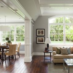 a living room filled with furniture next to a wooden floor covered in lots of windows