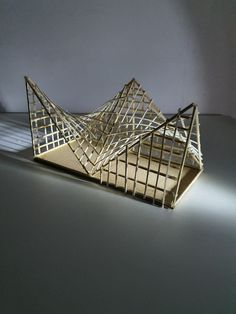 a sculpture made out of wood and wire on a table with light coming through it