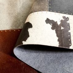 two different colored cow hides on the back of a leather chair with stitching