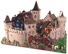 a lego castle is shown with lots of people around it and trees in the foreground