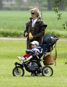 a woman walking with a stroller and baby in it