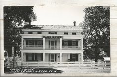 an old black and white photo of a large house with porches on the second floor