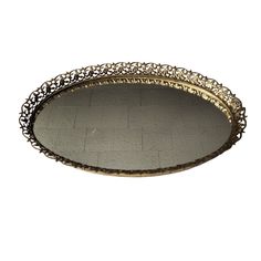 an oval metal tray with intricate designs on the edges and sides, set against a white background