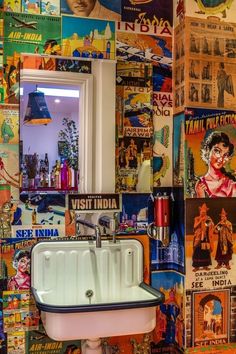 a sink and mirror in a room with colorful wallpapers on the walls behind it