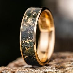 a close up of a ring on top of a rock with moss growing on it