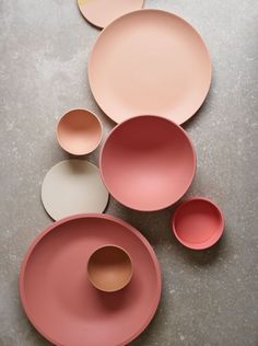 pink plates and bowls are laid out on the floor