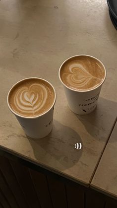 two cups of coffee sitting on top of a counter