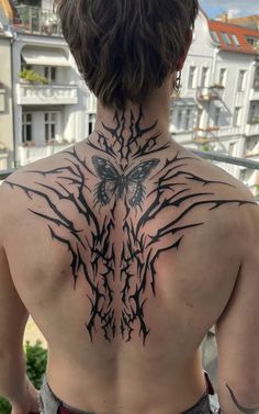 the back of a man's neck with an intricate tattoo design on his chest