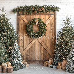 christmas trees and presents are arranged in front of a barn door with a wreath on it