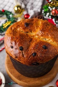 a loaf of bread sitting on top of a wooden cutting board next to christmas decorations