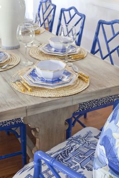 a wooden table topped with blue and white plates