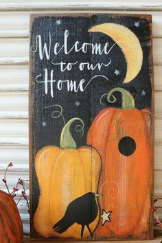 a wooden sign that says welcome to our home with pumpkins and a bird on it