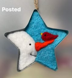 a felt star ornament with a bird and a cardinal on it's side