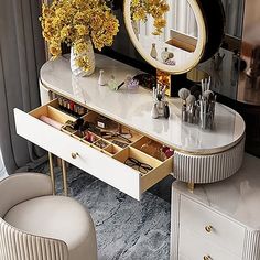 a dressing table with flowers in vases on it and two stools next to it