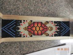 a cross - stitch beaded object is sitting on the floor