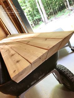 a wheelbarrow made out of wood in a garage