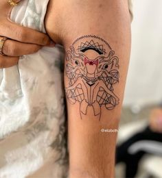 a woman's arm with a tattoo on it that has an image of a demon