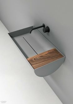 a wooden cutting board mounted to the side of a wall next to a metal hook