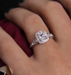 a woman's hand with a diamond ring on top of her finger and an engagement band