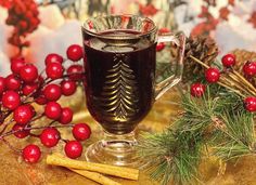 a glass mug filled with liquid surrounded by christmas decorations