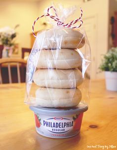 a stack of doughnuts wrapped in plastic sitting on top of a wooden table