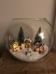 a glass bowl filled with snow and small houses