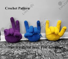 three crochet hand puppets sitting next to each other on top of a carpet