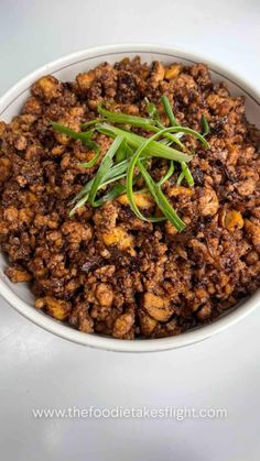 a white bowl filled with food on top of a table