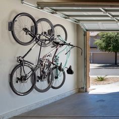 two bicycles mounted to the side of a white wall next to a parking garage door