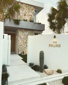 a house with a cactus in front of it and the words the palms written on the wall