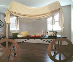 a table that has some food on it in the middle of a room with an awning over it