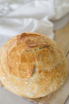 a loaf of bread sitting on top of a wooden cutting board