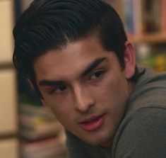 a close up of a young man with a serious look on his face, looking at the camera