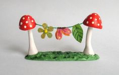 two mushrooms with leaves and flowers on a string