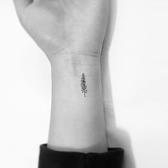 a small pine tree tattoo on the wrist