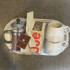 a coffee cup, mug and tea bag in a tray