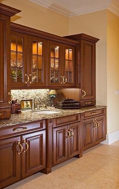 a kitchen with wooden cabinets and marble counter tops