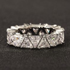 a wedding ring with four princess cut diamonds on the inside and outside, set in 18k white gold