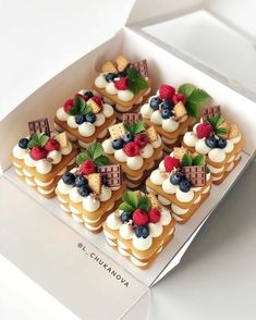 a box filled with lots of small desserts on top of a white countertop