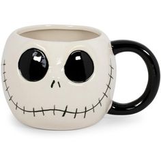 a black and white coffee mug with a face painted on the side, sitting in front of a white background