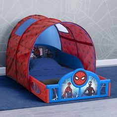 a child's bed with a spiderman tent on the bottom and two people inside