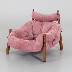 a pink chair sitting on top of a white floor next to a wooden frame and legs