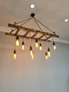 a chandelier made out of wooden planks with light bulbs hanging from it