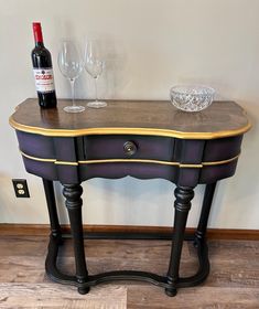 a table with a wine glass on it next to a bottle of wine and two glasses