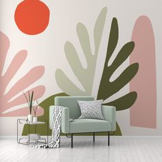 a living room with a couch, chair and plant wall mural on the wall behind it