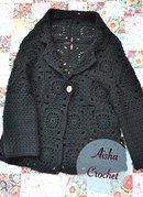 a black crocheted jacket sitting on top of a floral tablecloth with the words asha crochet written below it