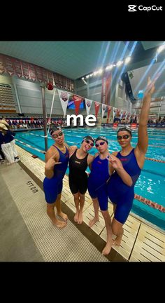 three women in blue swimsuits standing next to a swimming pool and posing for the camera