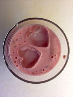 a smoothie in a glass with two hearts on it