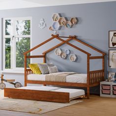 a child's bedroom with blue walls and wooden furniture, including a bed frame