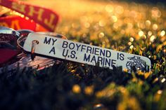 a keychain that says my boyfriend is u s marine on it sitting in the grass